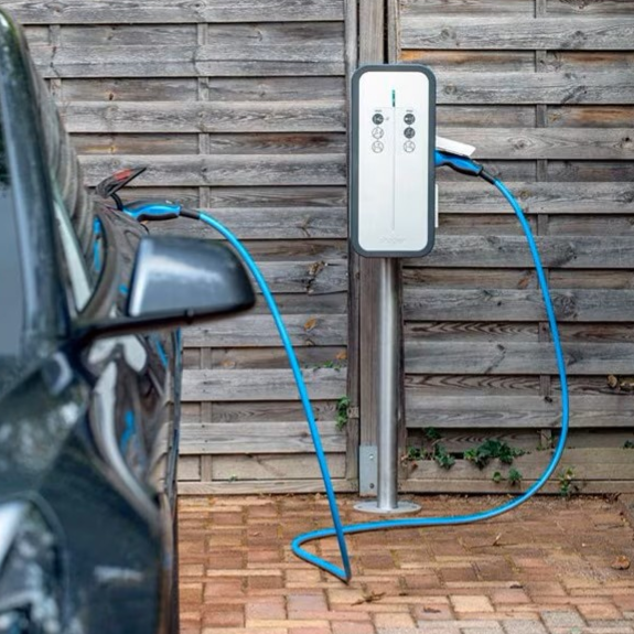 Borne de recharge pour voiture électrique à côté d'un véhicule garé à Chamagnieu