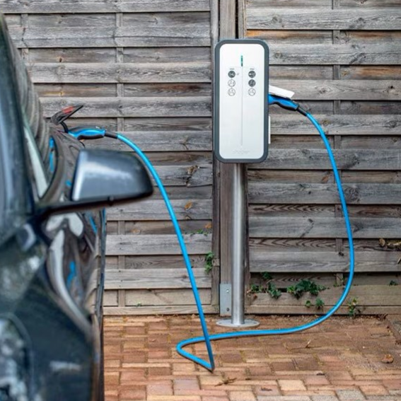 Borne de recharge pour voiture électrique à côté d'un véhicule garé à Saint-Romain-de-Jalionas
