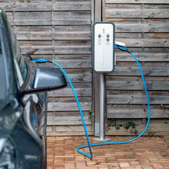 Borne de recharge pour voiture électrique à côté d'un véhicule garé à Colombier-Saugnieu.